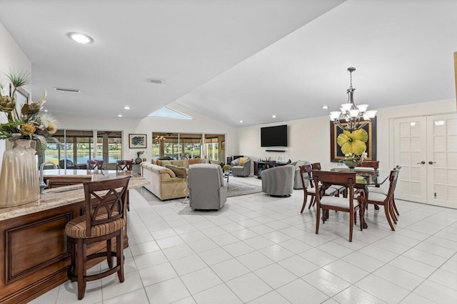 tiled living room featuring a chandelier, vaulted ceiling, and sink