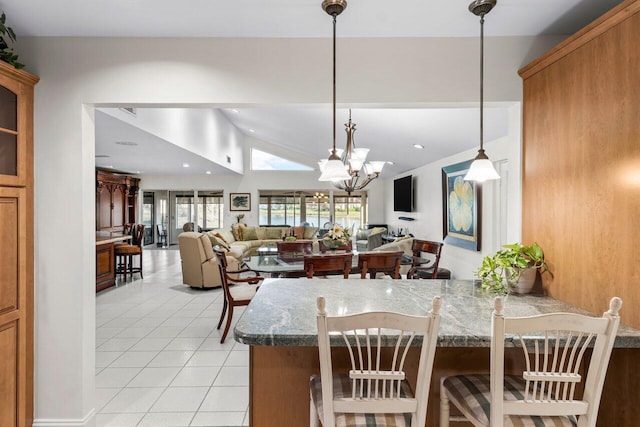 tiled dining area featuring a notable chandelier and vaulted ceiling