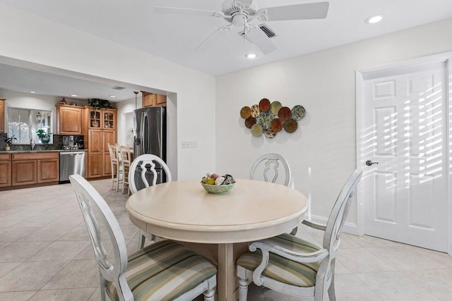 dining room featuring ceiling fan, sink, and light tile patterned floors