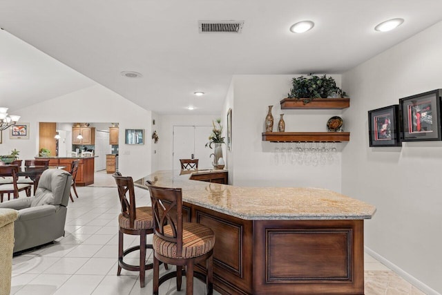 bar featuring light stone counters and light tile patterned floors