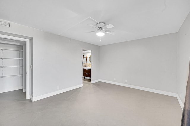 spare room with ceiling fan and built in shelves