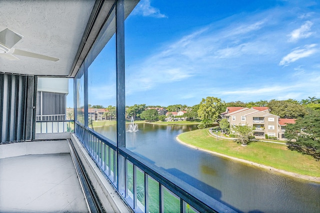 balcony with ceiling fan and a water view