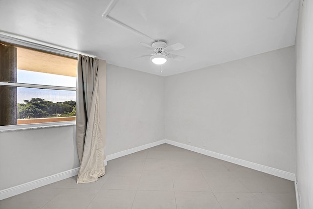 tiled empty room featuring ceiling fan