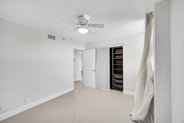 unfurnished bedroom with ceiling fan, a closet, and light tile patterned floors