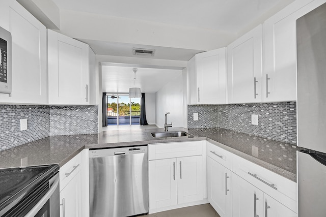 kitchen featuring decorative backsplash, appliances with stainless steel finishes, white cabinetry, and sink