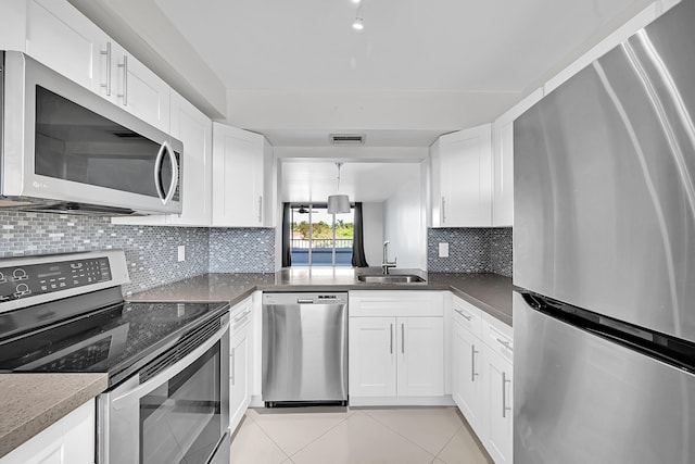 kitchen featuring white cabinets, sink, stainless steel appliances, and tasteful backsplash