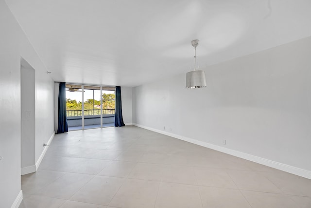 spare room featuring light tile patterned flooring and a wall of windows