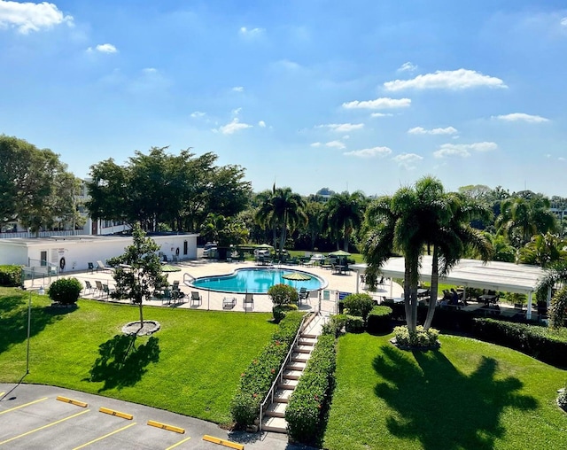 view of pool featuring a lawn and a patio