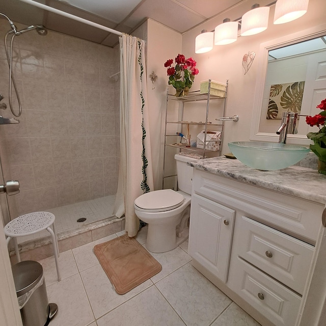 bathroom with toilet, a shower with curtain, vanity, and tile patterned floors