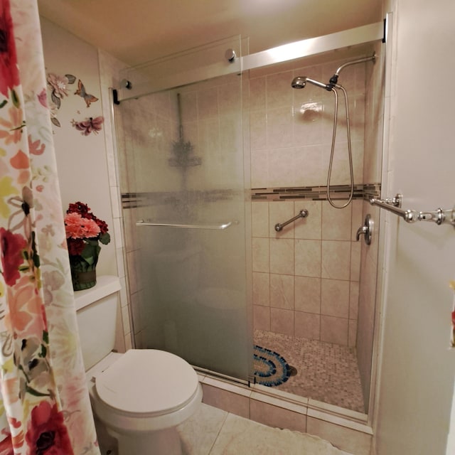 bathroom featuring tile patterned floors, curtained shower, and toilet