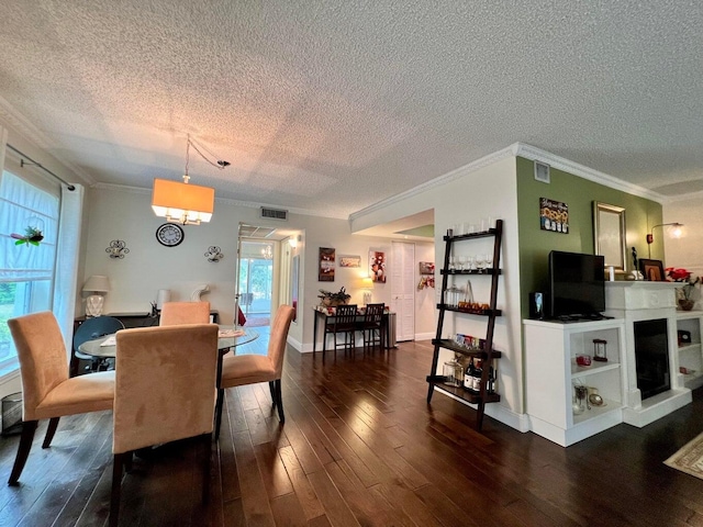 dining area with a textured ceiling, dark hardwood / wood-style floors, and ornamental molding