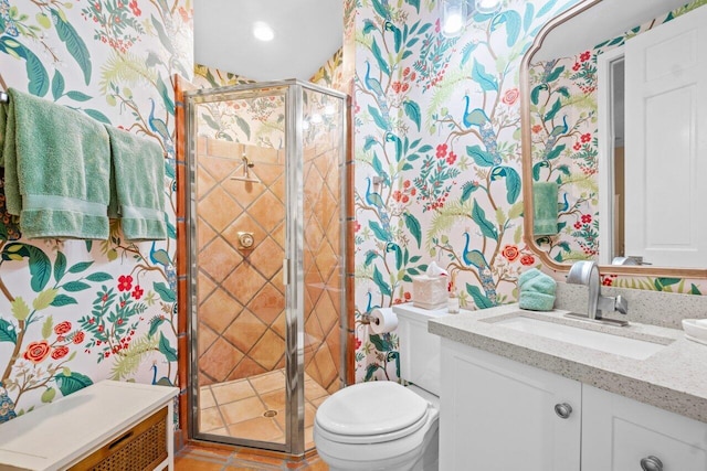 bathroom with tile patterned floors, vanity, an enclosed shower, and toilet