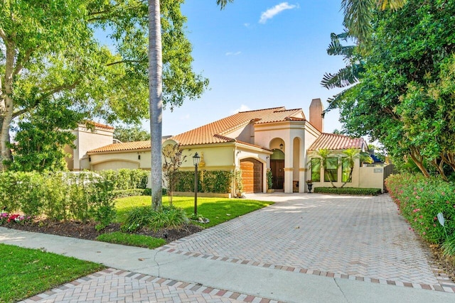 mediterranean / spanish home with a garage and a front yard