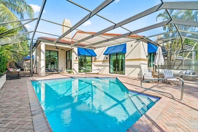 view of pool featuring ceiling fan, a lanai, and a patio