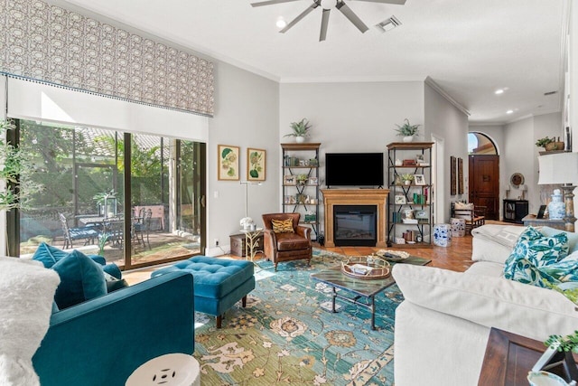 living room with ceiling fan, wood-type flooring, and ornamental molding