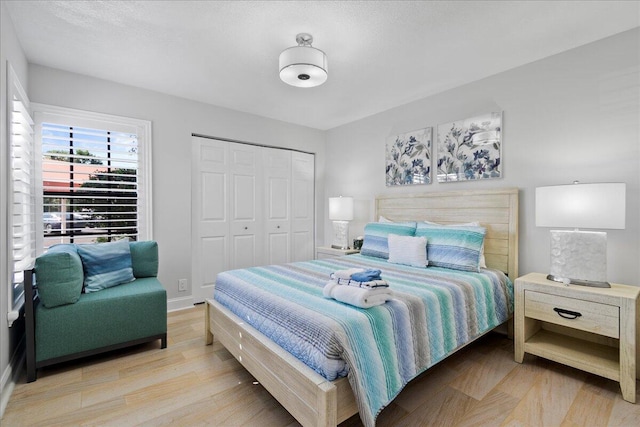 bedroom with light hardwood / wood-style floors and a closet