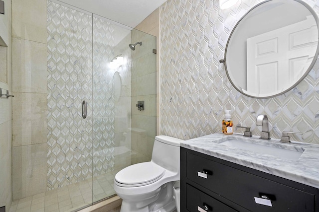 bathroom featuring vanity, toilet, walk in shower, tile walls, and tasteful backsplash