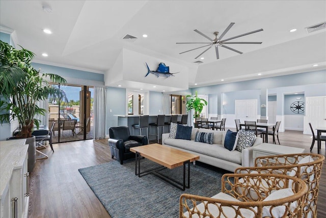 living room with hardwood / wood-style floors, ceiling fan, and crown molding