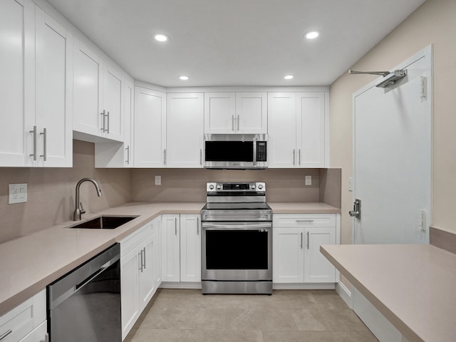 kitchen with sink, white cabinetry, stainless steel appliances, and light tile patterned floors