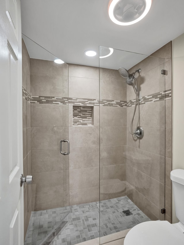 bathroom featuring walk in shower and toilet