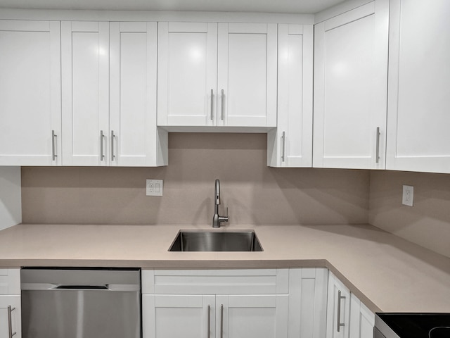 kitchen featuring backsplash, sink, dishwasher, range, and white cabinetry