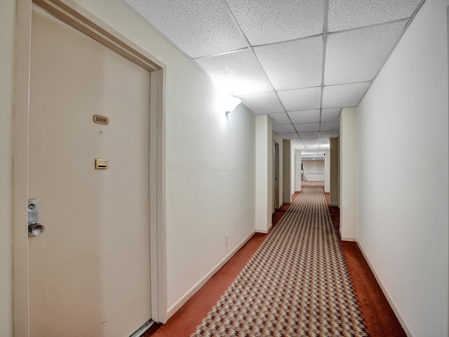 corridor with a paneled ceiling