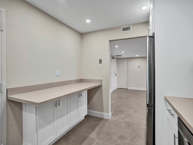 kitchen featuring white cabinetry, stainless steel refrigerator, and light tile patterned flooring