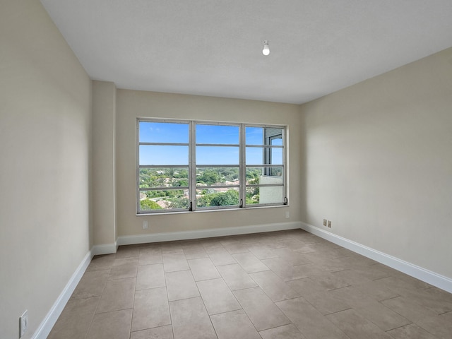 unfurnished room with light tile patterned flooring