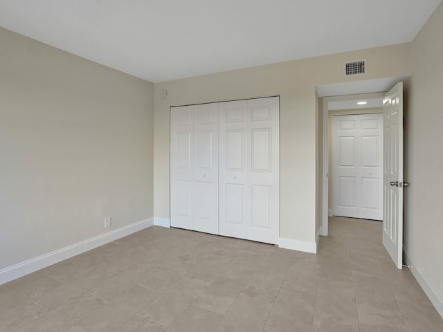 unfurnished bedroom featuring a closet and light tile patterned floors