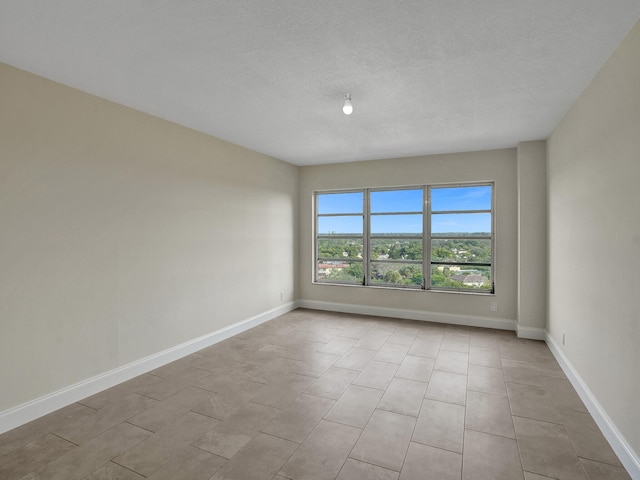 empty room featuring light tile patterned floors and a textured ceiling