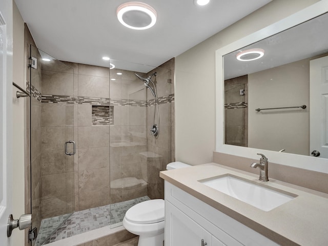 bathroom featuring vanity, toilet, and an enclosed shower