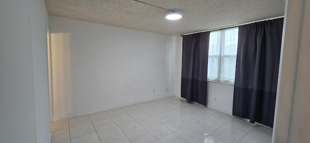 tiled empty room with a textured ceiling