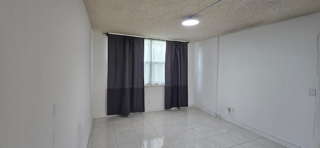 tiled spare room with a textured ceiling