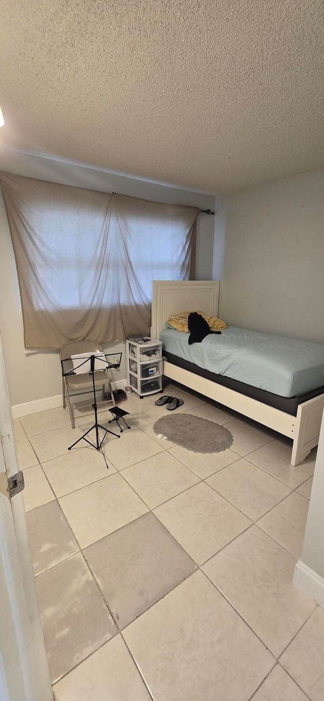 unfurnished bedroom featuring light tile patterned floors and a textured ceiling