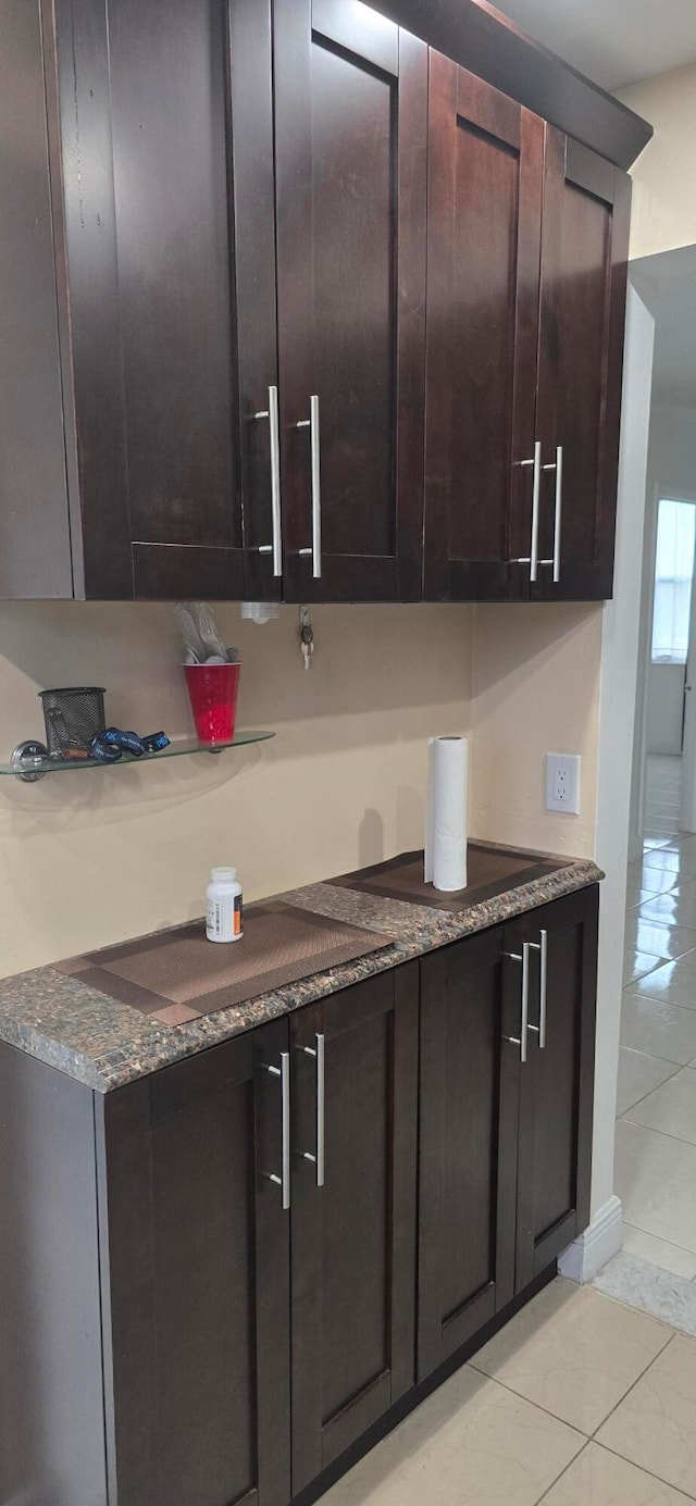 kitchen with light tile patterned flooring and dark brown cabinetry