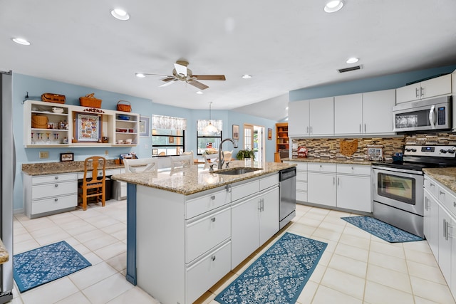 kitchen featuring sink, white cabinets, a center island with sink, and appliances with stainless steel finishes