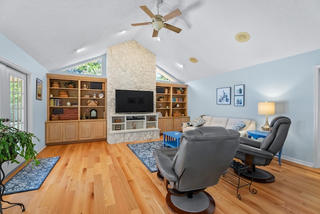 living room featuring ceiling fan, light hardwood / wood-style floors, and lofted ceiling