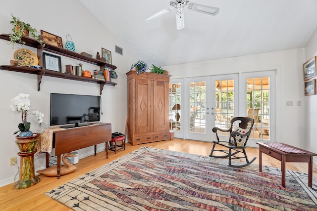 sitting room with ceiling fan, french doors, wood-type flooring, and vaulted ceiling