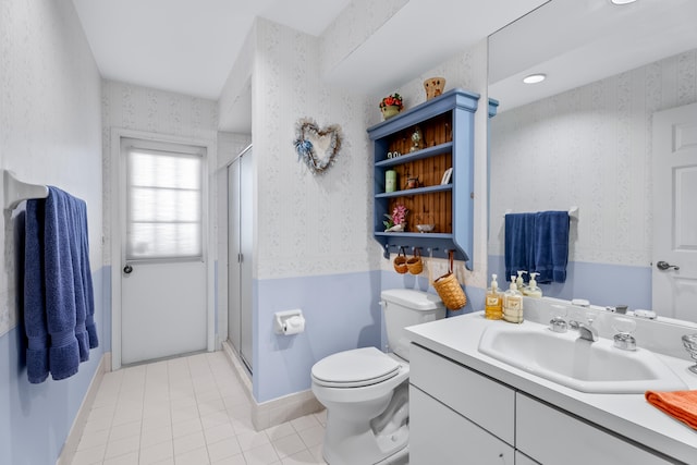 bathroom featuring toilet, vanity, tile patterned floors, and an enclosed shower