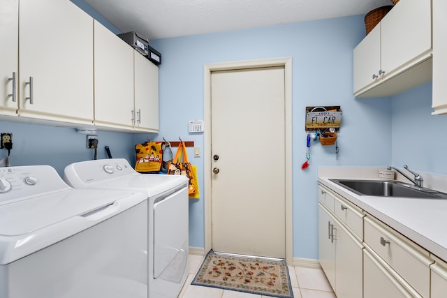 washroom featuring separate washer and dryer, sink, light tile patterned floors, and cabinets