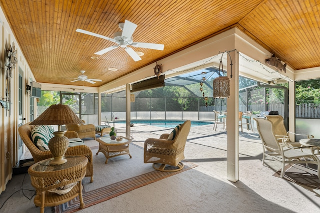 sunroom / solarium with ceiling fan, a pool, wooden ceiling, and vaulted ceiling