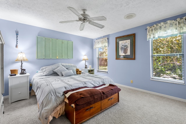 carpeted bedroom featuring a textured ceiling and ceiling fan