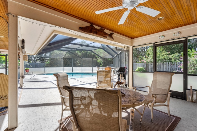 view of patio / terrace with a lanai, ceiling fan, and a fenced in pool