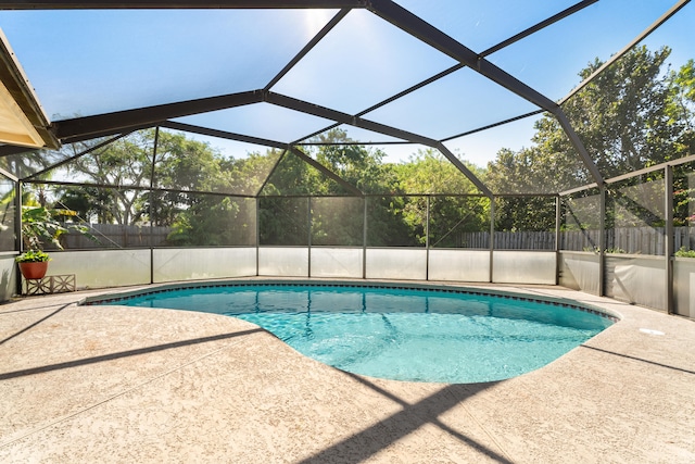 view of swimming pool featuring a lanai and a patio area