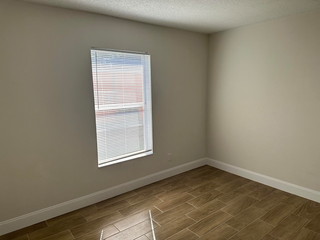 spare room with a textured ceiling and hardwood / wood-style flooring