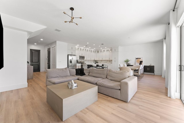 living room featuring light hardwood / wood-style floors and a chandelier