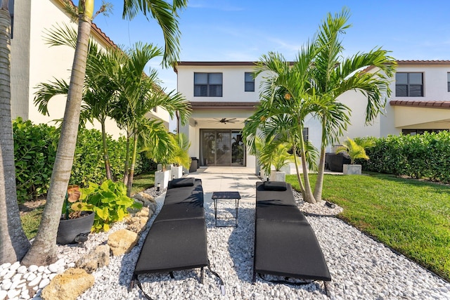 rear view of property featuring french doors and a lawn