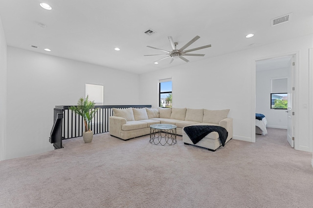 carpeted living room with ceiling fan