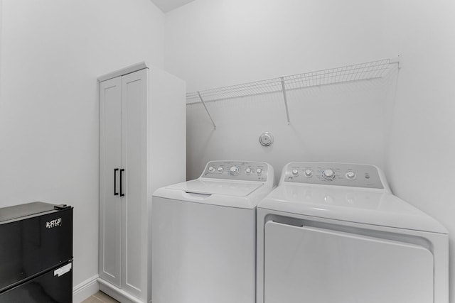 laundry area featuring washer and clothes dryer and cabinets