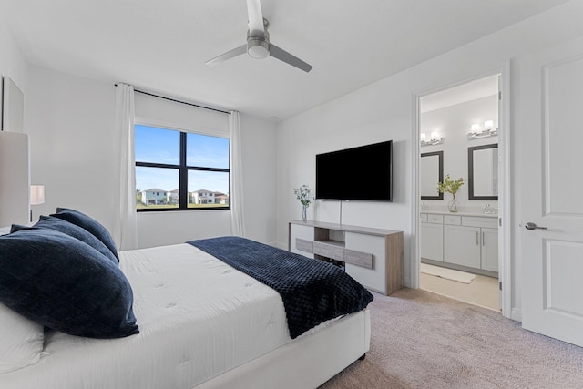 bedroom with connected bathroom, light carpet, sink, and ceiling fan